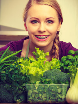 Woman in kitchen with green vegetables