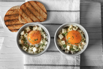 Baked eggs with cheese and bread on table