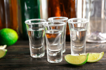 Tequila shots with lime slices and salt on table