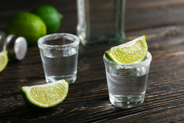 Tequila shots with lime slices and salt on table
