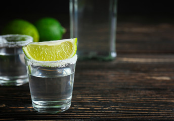 Tequila shot with lime slice and salt on table
