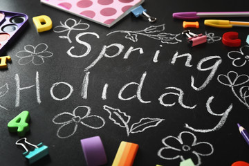 Text SPRING HOLIDAY written on chalkboard and different stationery