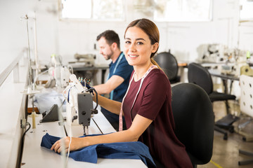 Pretty seamstress using a sewing machine