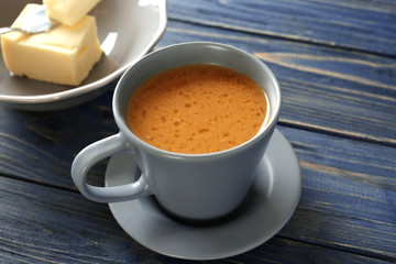 Cup of tasty butter coffee on wooden table