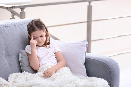 Little girl suffering from headache at home
