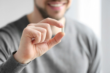 Hand of young man with pill, closeup