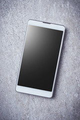 Overhead shot of smart phone on gray stone background