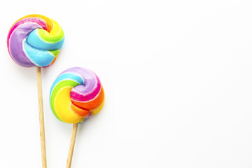 two rainbow color lollipops on white background