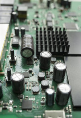 Detail of an electronic printed circuit board with many electrical components with swallow depth of field.