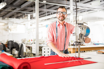 Hispanic designer cutting some fabric