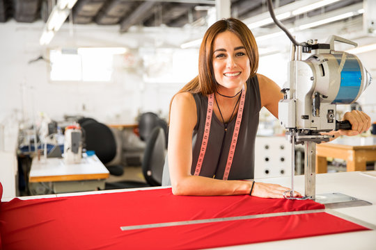 Woman using a fabric cutting machine in a factory