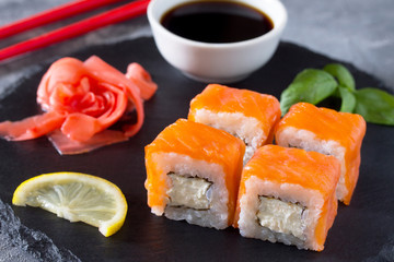 Roll Cheese salmon on a black slate board - salmon, soft cheese, nori, rice. © elena_hramowa