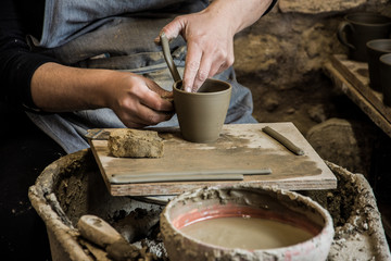 Woman potter at work creating some traditional cups of white clay, Margarites, Rethimno, Crete.