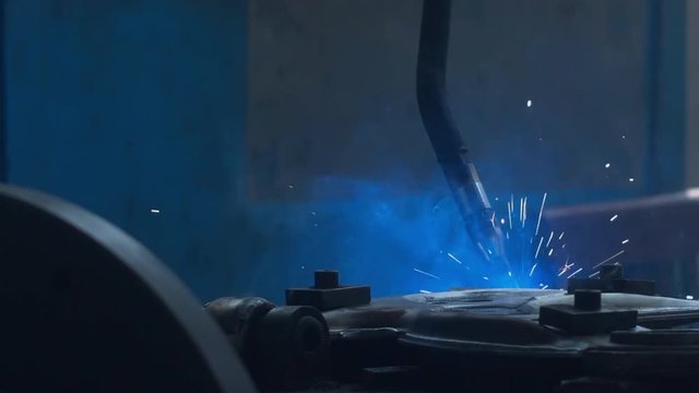 CU shot of robot arm welding car part on a factory. Industrial process, no people. 4K UHD 60 FPS