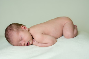 Naked newborn baby boy sleeping