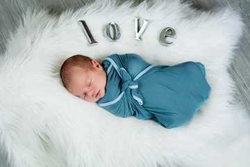 Newborn baby boy sleeping and swaddled 