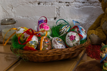 Wielkanocny świąteczny koszyk pisanek na tle białej cegły