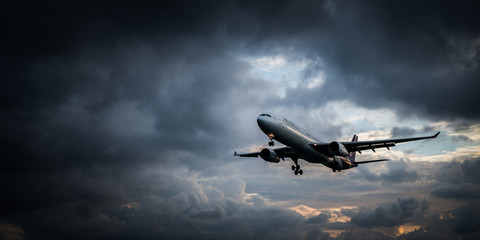 Fototapeta premium View from the beach on the landing airplane isolated over beautiful cloudy dramatic looking sky background