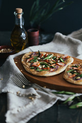 Pizza mit Stremellachs, Spargel und Pinienkernen: selbstgemachter Teig, rote Zwiebel, Frischk&auml;se mit Cayenne Pfeffer, Chilf&auml;den. Fotografiert mit Blende 2,8.