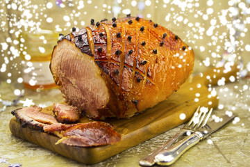 Christmas roasted ham with apricot glaze and cloves and snow decoration