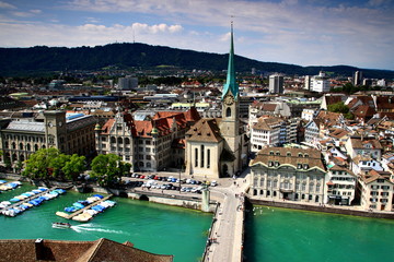 Cityscape of Zurich old town: the reformed Fraumunster Church, Munsterbrucke bridge on the river Limmat in the city center, Uetliberg in the background, seen from Grossmunster cathedral, Switzerland.