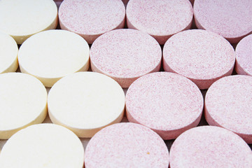 Stack of vitamin mineral supplement effervescent tablets pattern texture. Multivitamin supplement tablet. Soluble Vitamin. Fizzy tablet. Orange flavored effervescent tablets. 