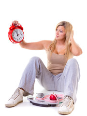 Woman holding apple, measuring tape and clock