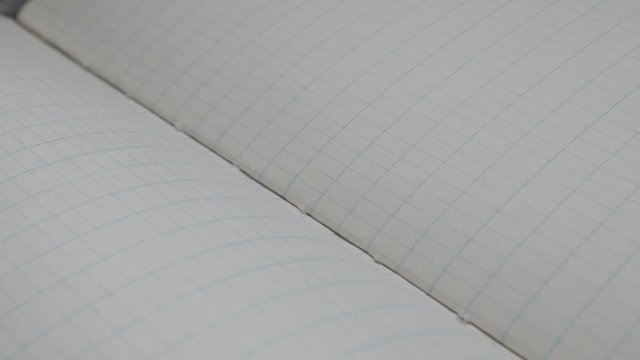 School scrap book white surface slow pan 4K 2160p 30fps UltraHD footage - Close-up of squared paper notebook writing pages 3840X2160 UHD panning video 