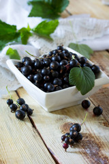 Berries of black currant on a wooden background. The concept of a healthy diet and diet.