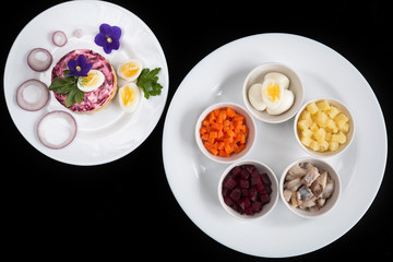 Dressed herring. Layered salad with herring. On a black background.