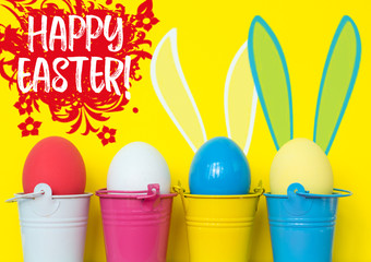 Bright dyed eggs in colored buckets with rabbit ears.  Happy Easter Card