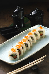 Sushi Roll with fish in a beautiful blue plate.