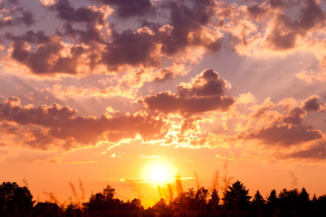 Obraz na płótnie Canvas Sonnenuntergang über Feld mit Wolken