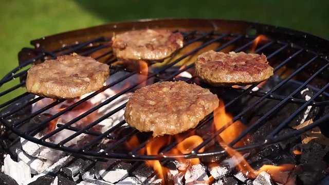 Beef burgers cooking on a barbecue grill