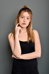 Young brunette lady posing on grey background