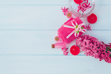 Spa and wellness composition with perfumed lilac flowers water in wooden bowl and terry towel on gray stone background, aromatherapy, top view, flat lay