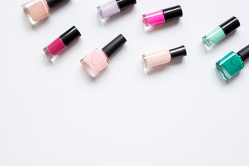Obraz premium Bottles with nail polish over white background top view mockup