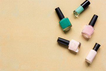 Obraz premium Bottles with nail polish over orange background top view mockup