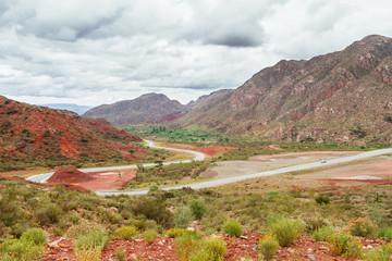 Valley with a curved road between red hills in La Rioja, Argentina