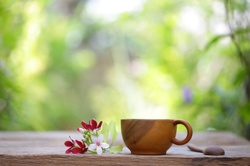Wooden cup and flowers on wooden table