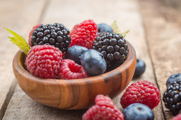 Blueberries and raspberries bowl on wooden table