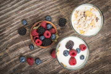 Top view of glasses with healthy breakfast, yogurt and berry fruit