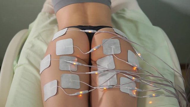 Close up shot of woman at electro stimulation therapy. Electro bio stimulation of thighs and buttocks. Rejuvenate therapy. Hardware cosmetology.