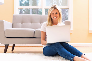 Happy young woman using her laptop