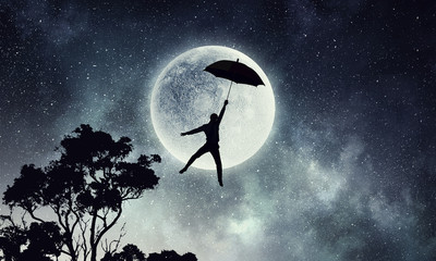 Obraz na płótnie Canvas Man fly on umbrella . Mixed media