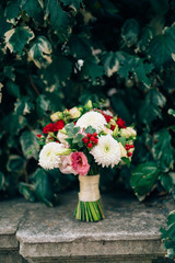 Wedding bridal bouquet of roses, chrysanthemums, Eucalyptus Baby Blue on the rocks. Wedding in Montenegro, Adriatic.