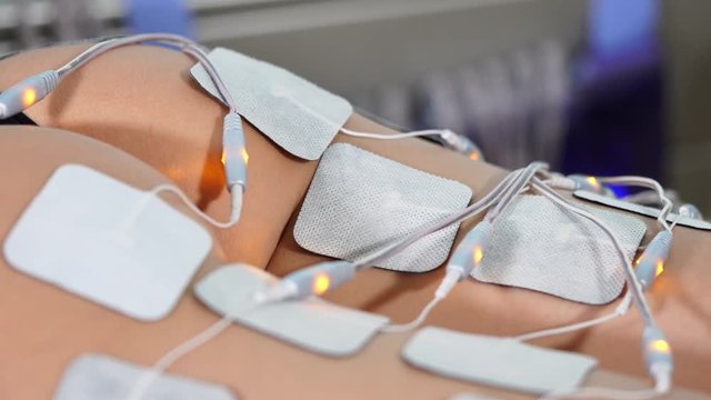 Close up female patient in beauty salon. Performing electro stimulation of butt. Concept of hardware cosmetology