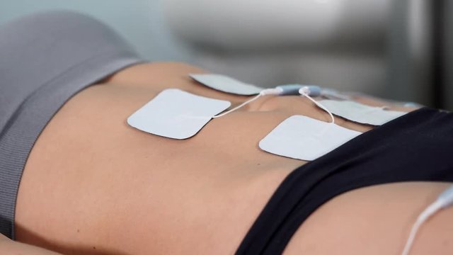 Close up antiage procedure. Female patient getting electro stimulation of tummy. Rejuvenate procedure. Hardware cosmetology