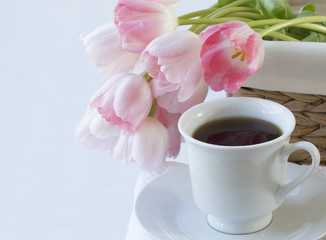 white cup of black coffee with pink tulip on  white background