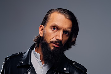 A man with long hair dressed in a black leather jacket.